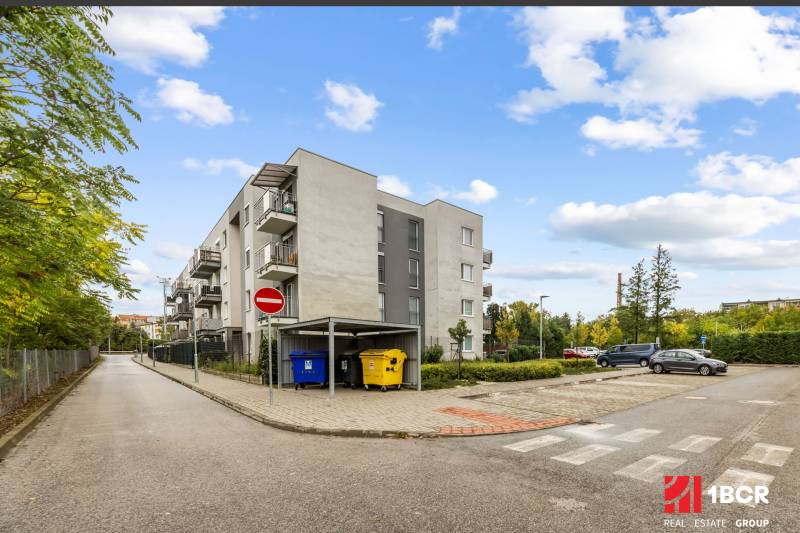 Bytový dům na ulici Mahulanka v Pezinku s parkovištěm a kontejnery.