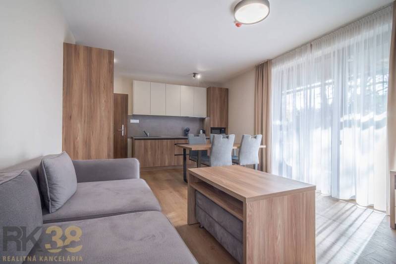 Obývací pokoj v 2-pokojovém bytě s nábytkem a podlahou s dřevěným dekorem.