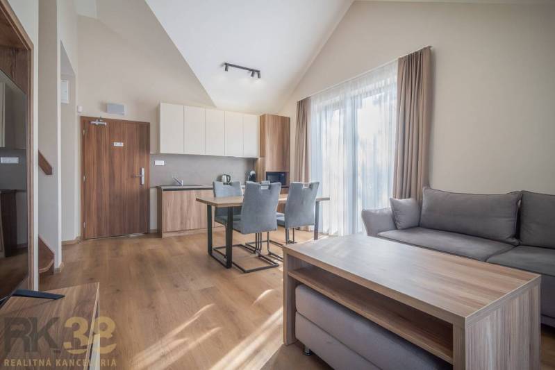 Světlý 2-pokojový byt s podlahou s dřevěným dekorem, pohodlným sezením a kuchyní.