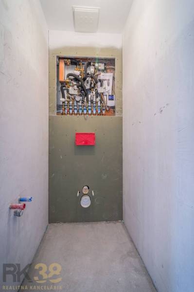 Instalace sanitárního zařízení v 2-pokojovém bytě s podlahou s dřevěným dekorem.