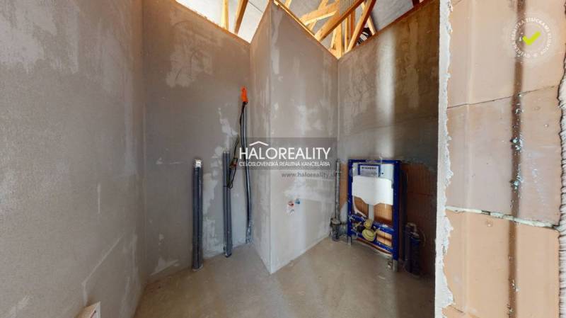 Nezařízená místnost ve stavbě rodinného domu, s viditelnými instalacemi.