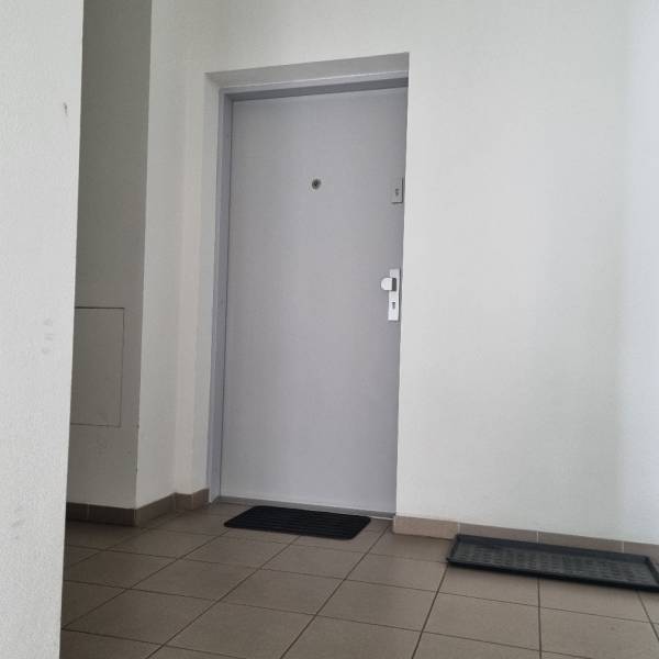 Eloxované dveře a dlažba v garsonce.