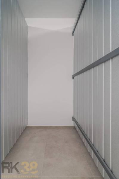 Úložný prostor s kovovými stěnami, podlaha s dřevěným dekorem v 3-pokojovém bytě.