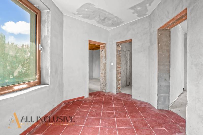 Rodinný dům s červenou dlažbou, omítnuté stěny a tři otevřené průchody.