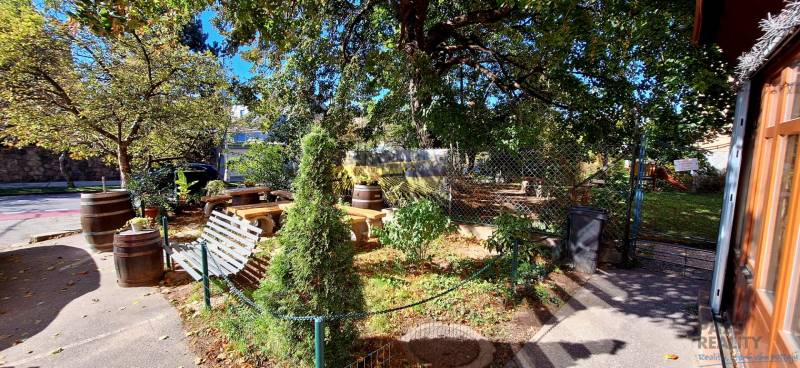 Zahrada s lavičkami a stromy v obchodních prostorech na Prokopa Velikého v Bratislavě - Starém Městě.