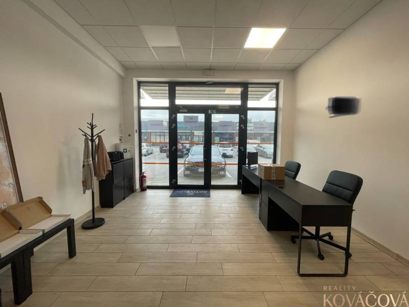 Interiér obchodních prostor s nábytkem a podlahou s dřevěným dekorem.