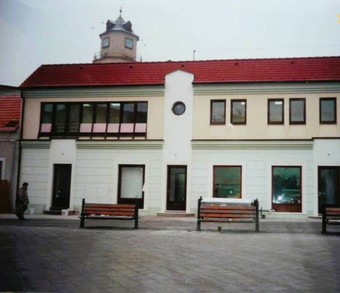 Obchodní prostory na Štúrově náměstí v Trenčíně s věží v pozadí.