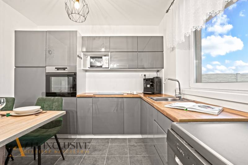 Kuchyně s šedou linkou, vestavnou troubou a mikrovlnkou v rodinném domě.