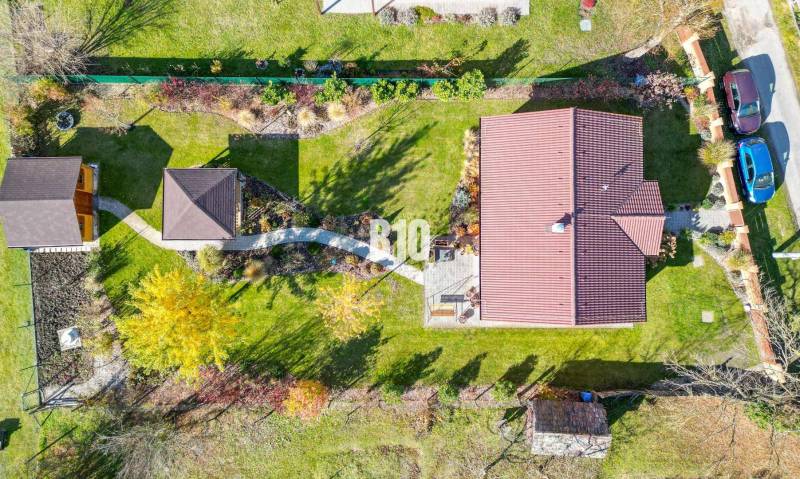 Rodinný dům v Bílikových Humencích s velkou zahradou a dvěma auty na dvoře.