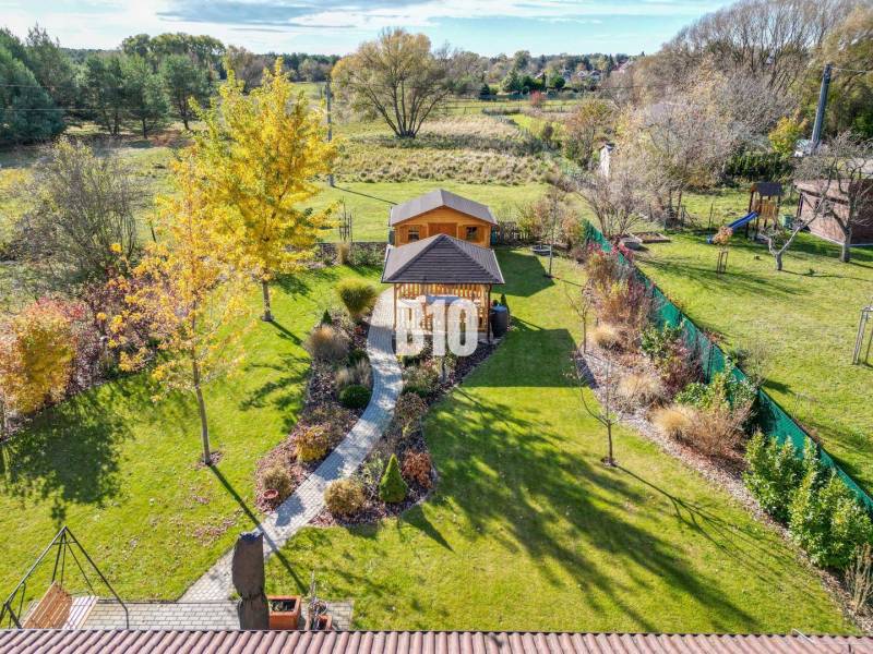 Zahrada u rodinného domu v Bílkove Humence se zahradním altánkem a zelení.