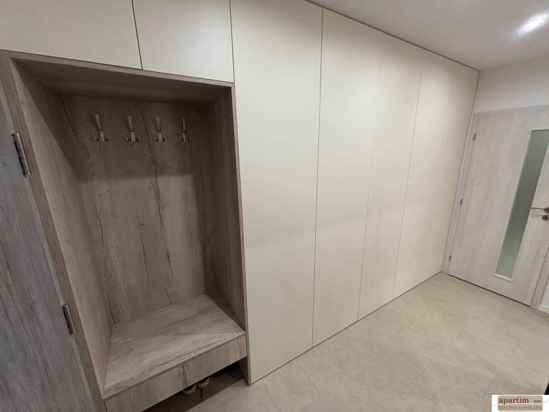 Vestavěná skříň s háčky a poličkou v 2-pokojovém bytě.