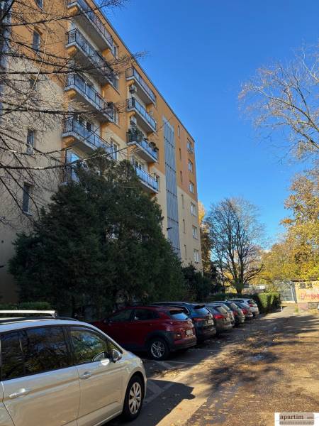 Bytový dům se zaparkovanými auty na Zálužické ulici v Bratislavě - Ružinově.