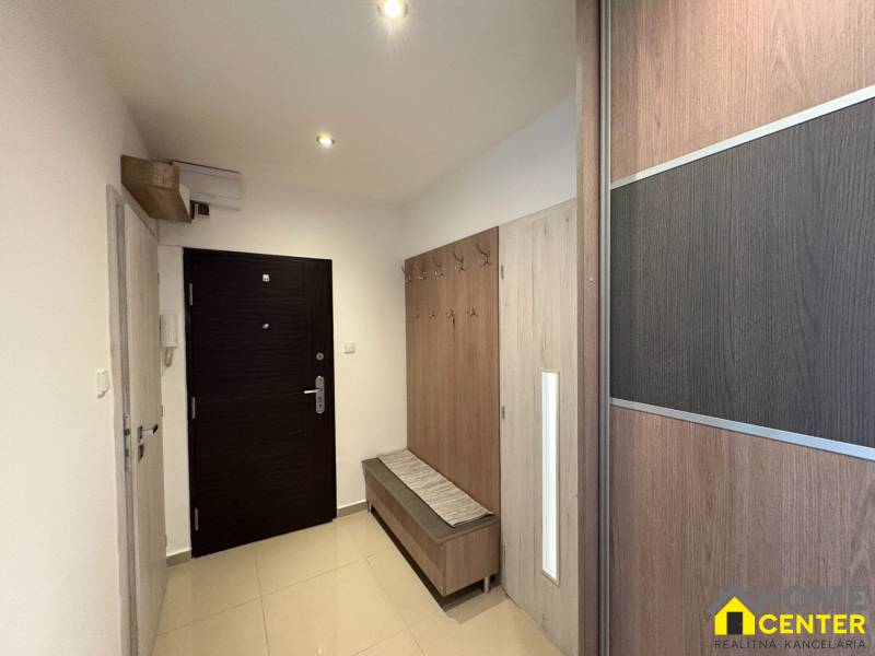 Vstupní hala 3pokojového bytu se skříní a věšákem, světlé prostředí.