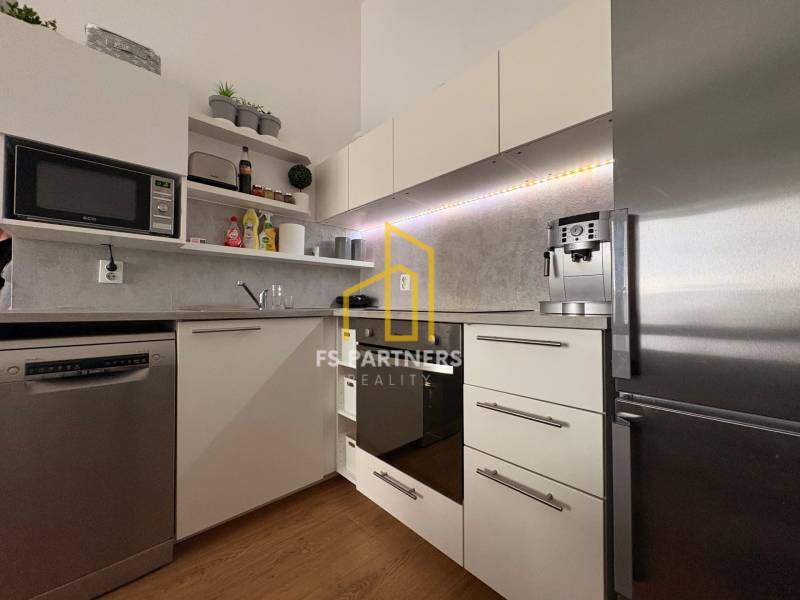 Kuchyně v 2pokojovém bytě s podlahou s dřevěným dekorem a moderními spotřebiči.