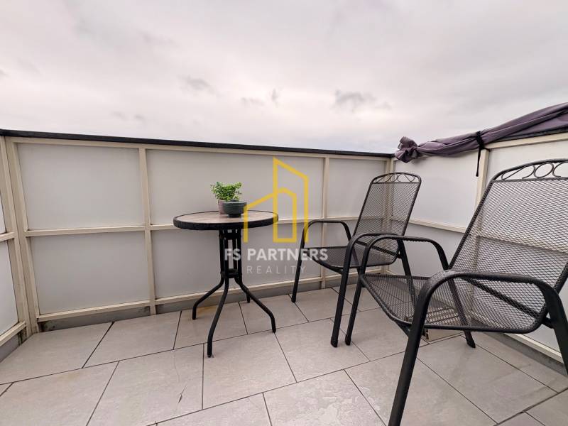 Balkon 2-pokojového bytu v Komárně se dvěma židlemi a stolkem na dlažbě.