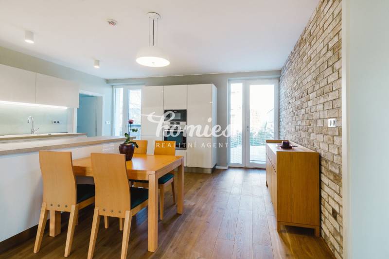 Kuchyně v rodinném domě s cihlovou stěnou a podlahou s dřevěným dekorem.