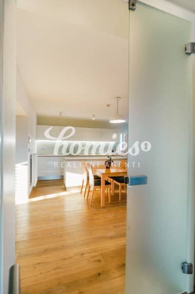 Kuchyně v rodinném domě s podlahou s dřevěným dekorem a jídelním stolem.