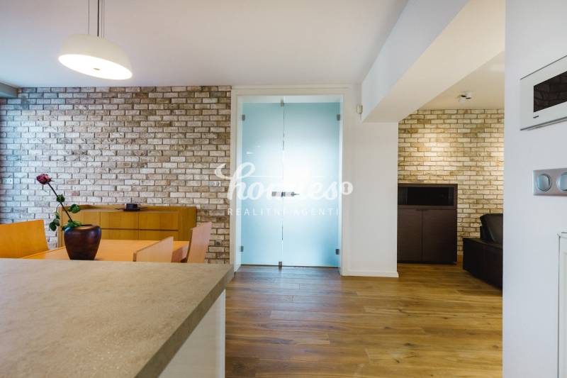 Jídelna rodinného domu s cihlovou stěnou a podlahou s dřevěným dekorem.