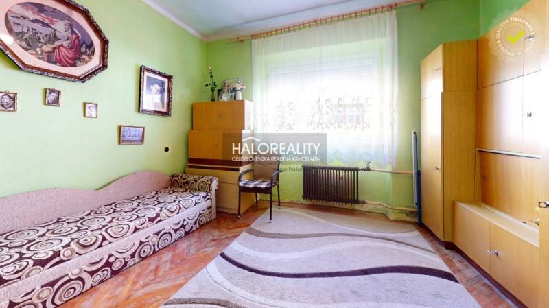 Obývací pokoj rodinného domu s barevnou stěnou, nábytkem a podlahou s dřevěným dekorem.