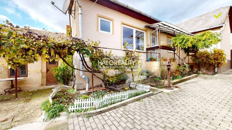 Rodinný dům v Lučenci s předzahrádkou, vinnou révou a dlažbou na dvoře.