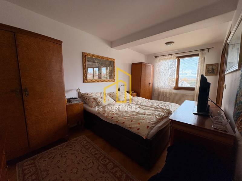 Ložnice v bytě s 5 a více pokoji s kobercem a dřevěnými skříňkami.