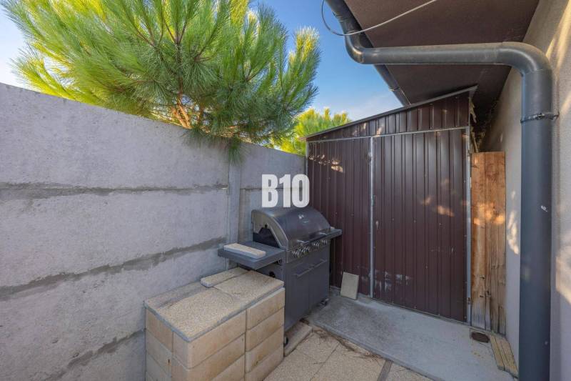 Zahrada v Mostě u Bratislavy s grilem a dřevěným přístřeškem u rodinného domu.