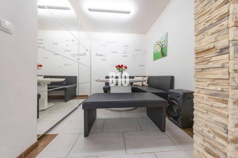 Interiér rodinného domu s posezením, zrcadlovou stěnou a dekorativním obkladem.