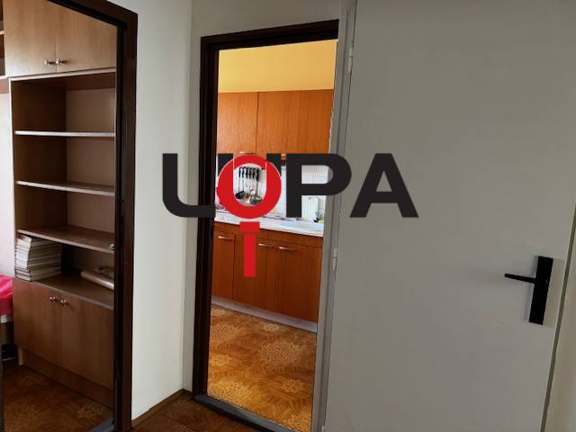 Chodba se vstupem do kuchyně, podlaha s dřevěným dekorem v 3-pokojovém bytě.