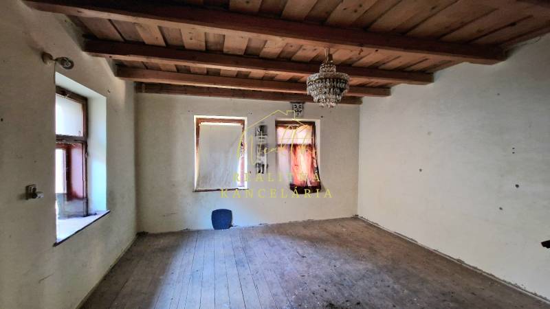 Pokoj v rodinném domě s dřevěným stropem a podlahou s dřevěným dekorem.