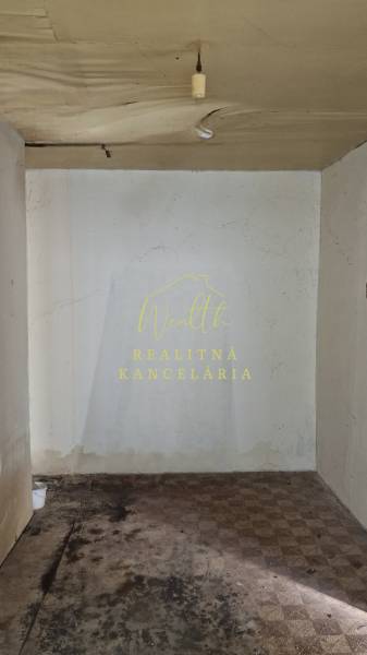 Interiér rodinného domu s poškozeným stropem a podlahou se stopami poškození.