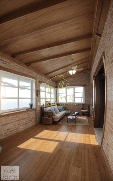 Interiér rodinného domu s cihlovými stěnami, podlahou s dřevěným dekorem a pohodlným sezením.