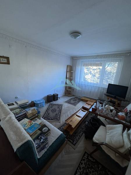 Obývací pokoj v 3-pokojovém bytě s podlahou s dřevěným dekorem a nábytkem.