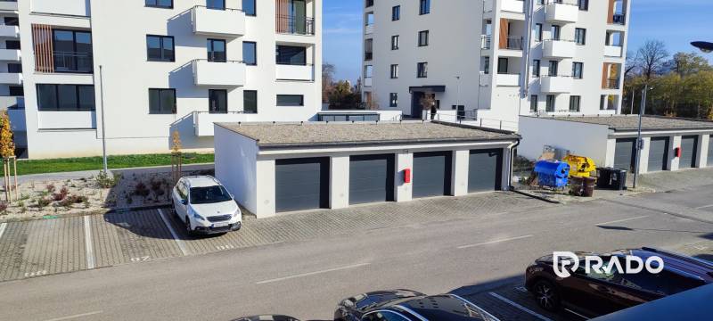 Pohled na Predmerského ulici v Trenčíně s bytovým domem a parkováním.