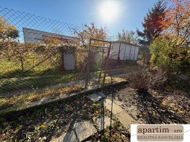 Zahrady na Střední ulici v Bratislavě-Ružinov s plotem a zelení.