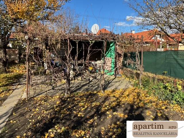 Zahrada na Střední ulici v Bratislavě - Ružinově s vinnou révou a přístřeškem.