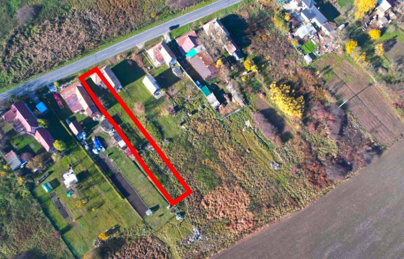 Letecká perspektiva na pozemky pro bydlení v obci Radnovce s hlavní silnicí.