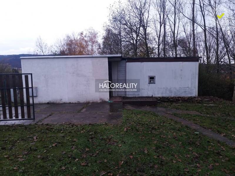 Rekreační pozemky v Nitrianskem Rudnu s jednoduchou stavbou obklopenou přírodou a stromy.