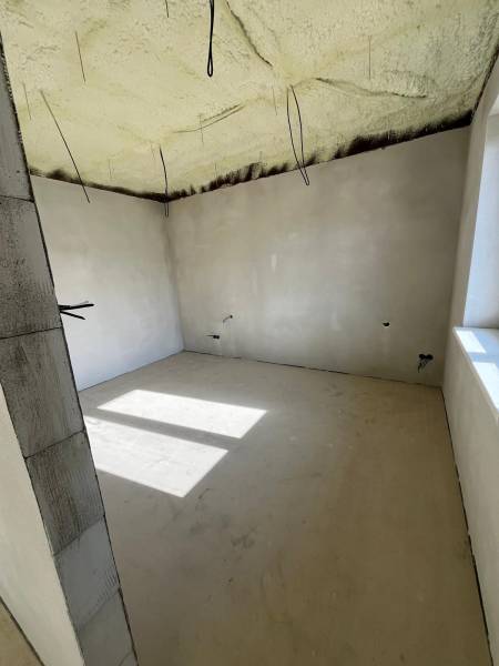 Izolovaný strop v rodinném domě na ulici Vyšná Šebastová. Světlý pokoj s velkým oknem.