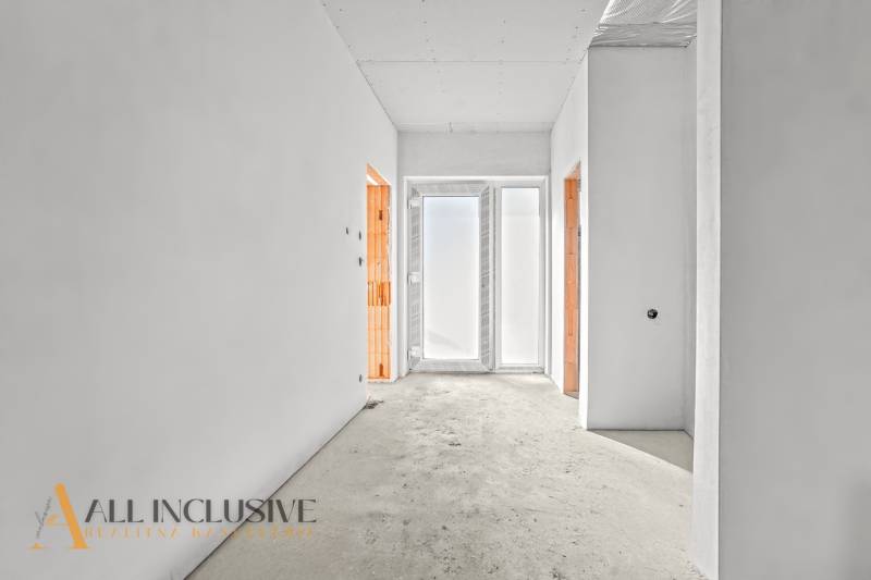 Světlá chodba v rodinném domě se dvěma otevřenými dveřmi a matným sklem.