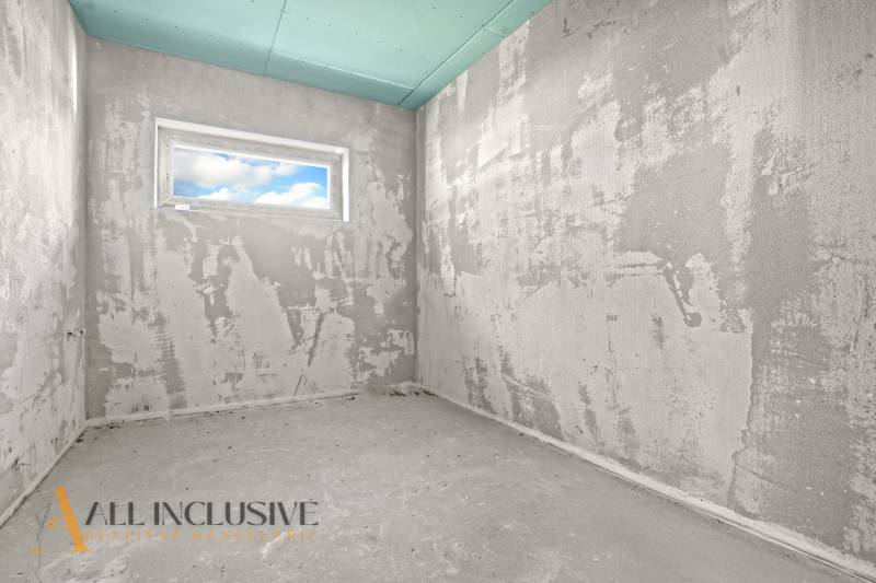 Hrubá stavba místnosti v rodinném domě s oknem a neopracovanými stěnami.