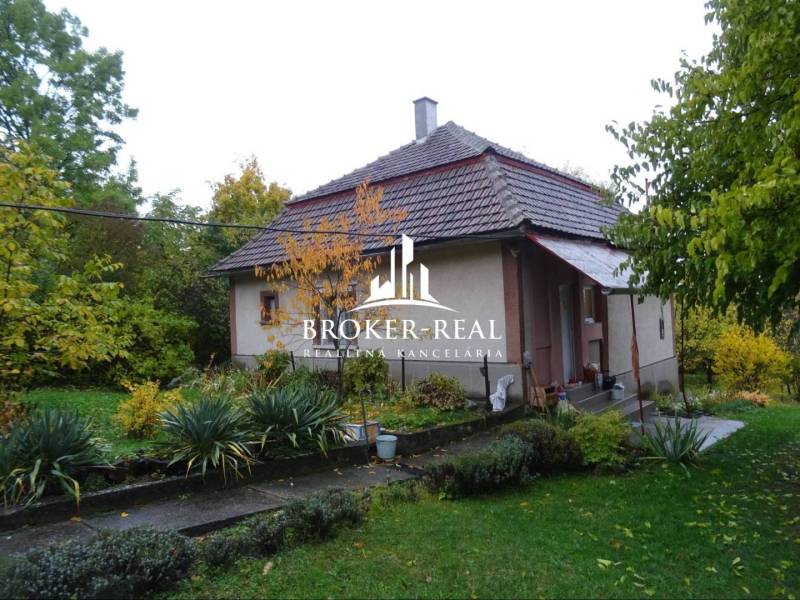 Rodinný dům ve Fony s velkou zahradou, obklopený zelení a stromy.