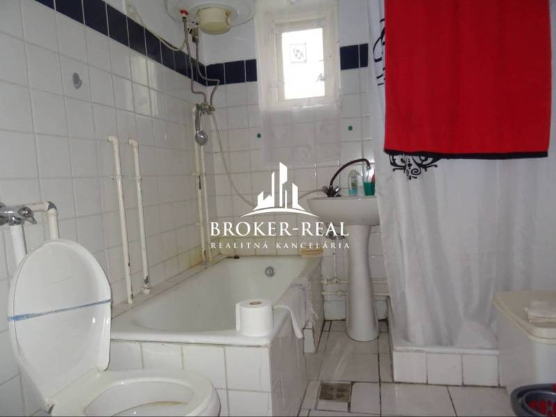 Koupelna s vanou a bílými kachličkami v rodinném domě.