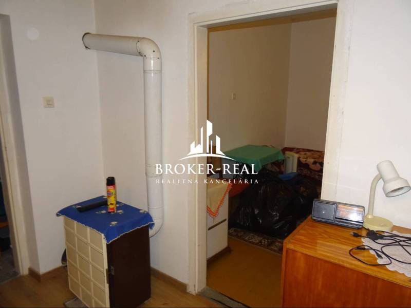 Interiér rodinného domu s topným tělesem, nábytkem a podlahou s dřevěným dekorem.