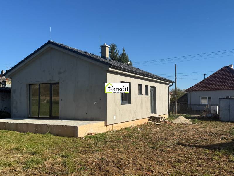 Rodinný dům v Tesárskych Mlyňanoch s neomítnutou fasádou a betonovou terasou.