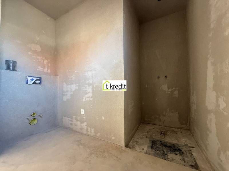 Nedokončená koupelna v rodinném domě s přípravou na instalace.