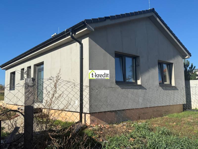 Rodinný dům v Tesárskych Mlyňanoch s šedou fasádou a okny, oplocený plotovým pletivem.