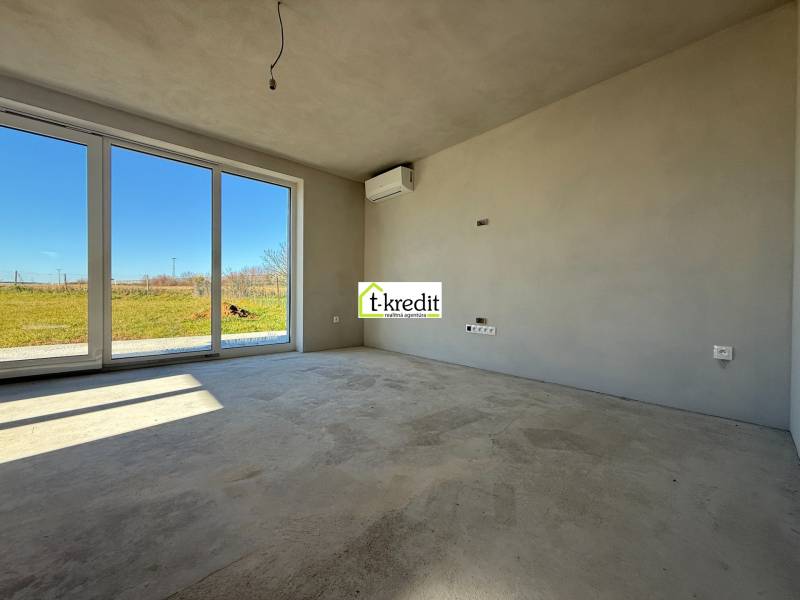 Prostorný pokoj v rodinném domě s velkými okny a výhledem do zahrady.