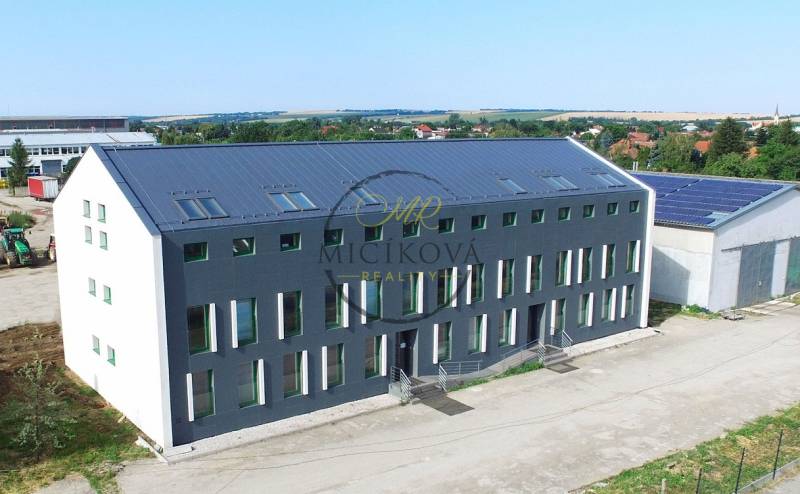 Budova na Levické ulici ve Vráblech s kancelářemi, moderní architektura a zelené okolí.