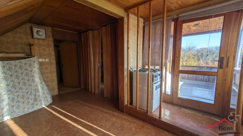 Interiér rodinného domu s dveřmi na terasu a stěnami s dřevěným dekorem.