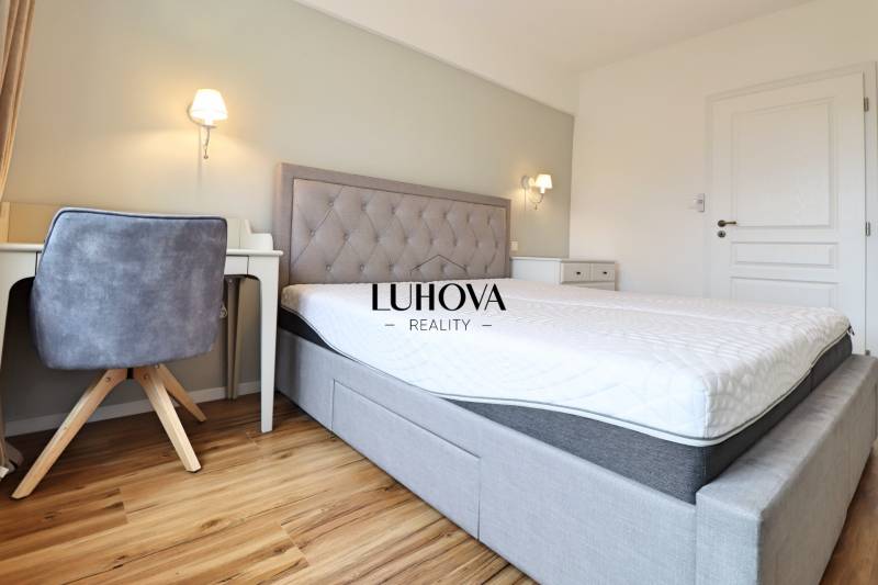 Ložnice v 3pokojovém bytě s komfortní postelí a podlahou s dřevěným dekorem.